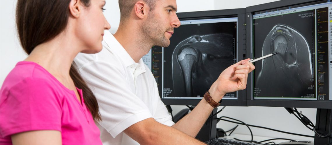 Radiologist councelling a patient using images from x ray computed tomograpy or MRI